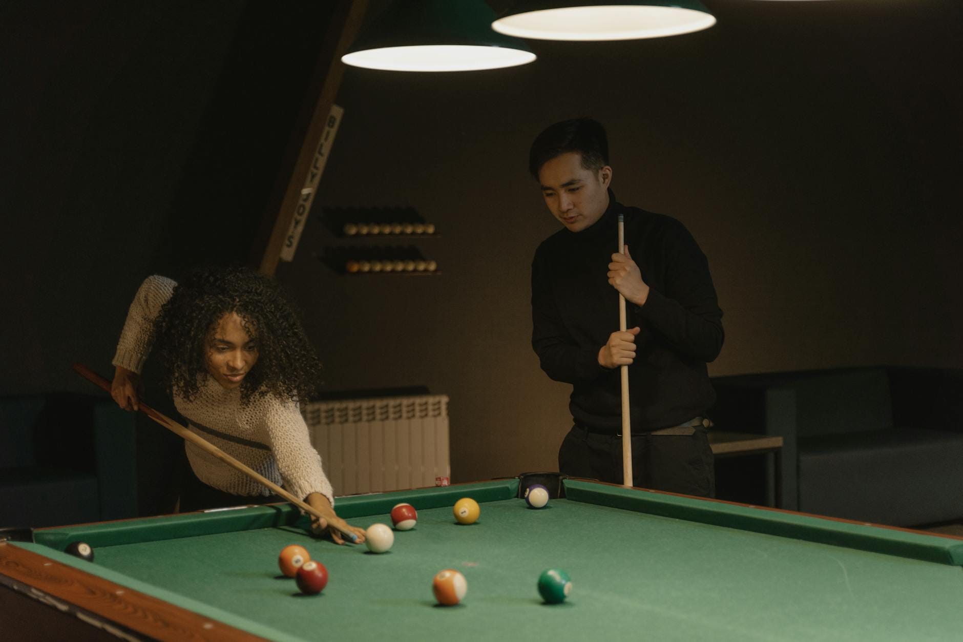 Dwóch przyjaciół gra w bilard w przytulnym wnętrzu