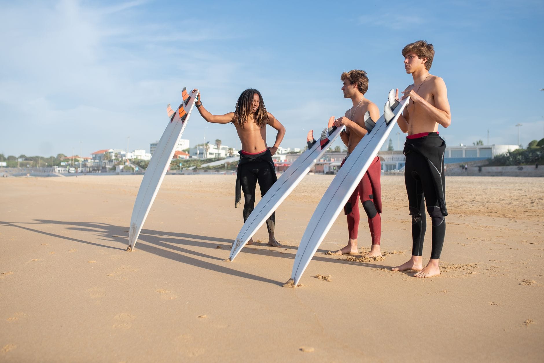 Młodzi surferzy z deskami na słonecznej plaży w Portugalii