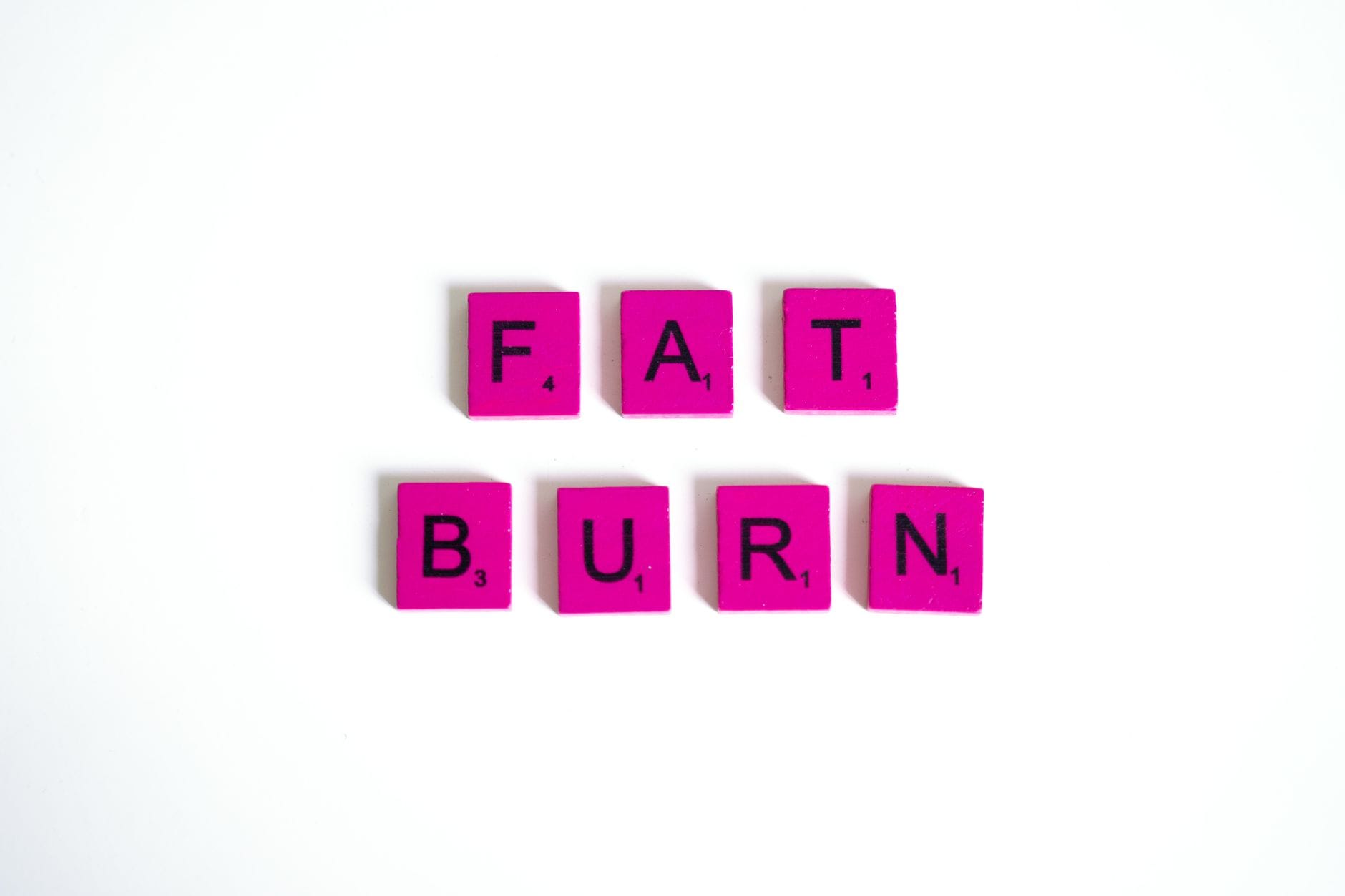 Różowe kafelki scrabble układające się w napis Fat Burn na białym tle Różowe kafelki scrabble układające się w napis Fat Burn na białym tle